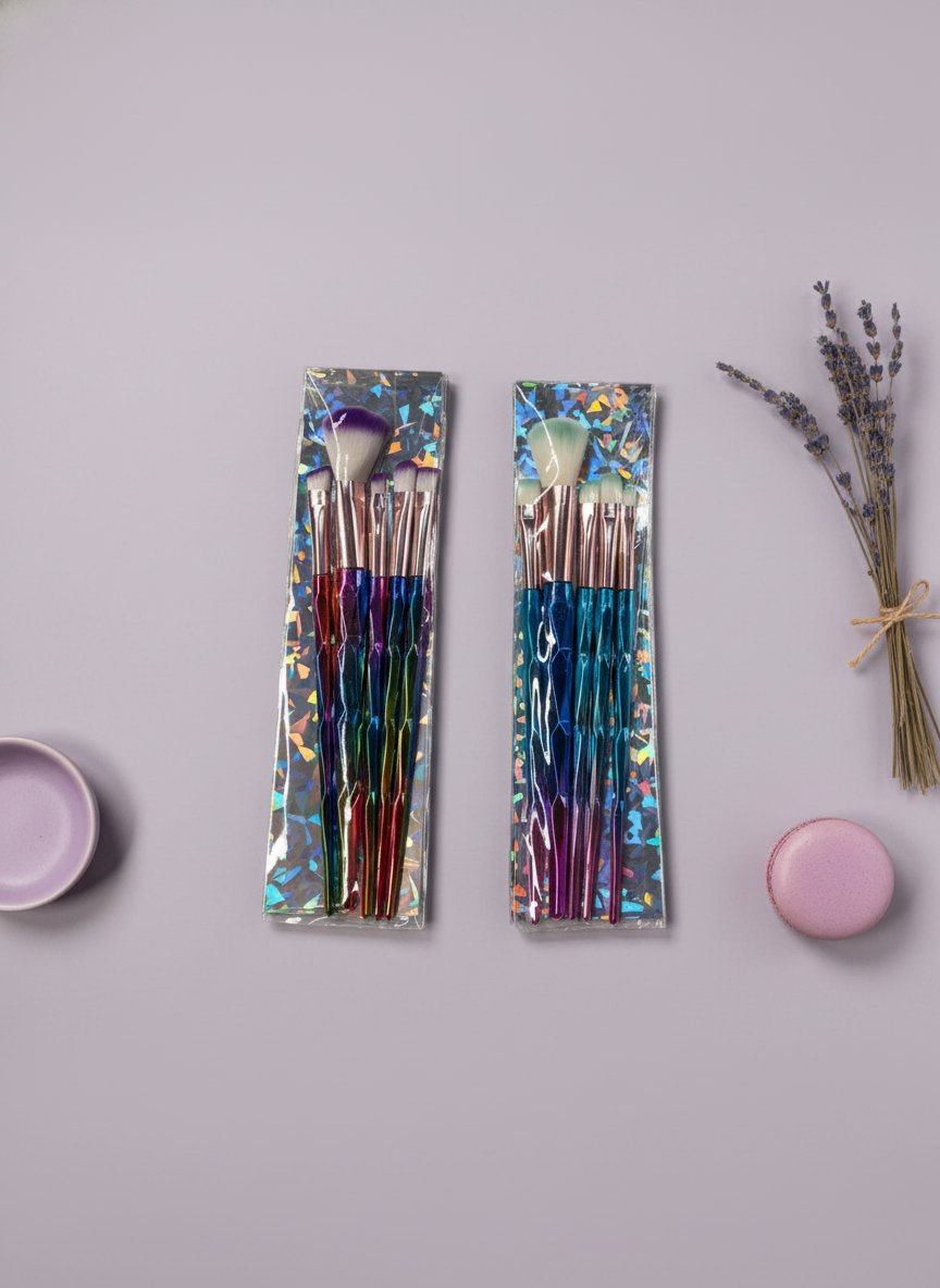 Set 5 pennelli trucco con manici multicolore, packaging olografico, su sfondo lilla con lavanda e accessori cosmetici