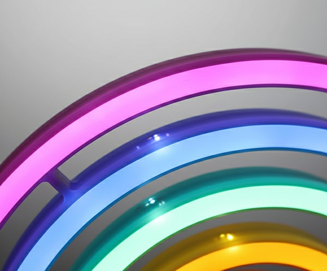 Lampada neon rainbow con strisce curve colorate: rosa, viola, blu, azzurro, verde e giallo su sfondo grigio
