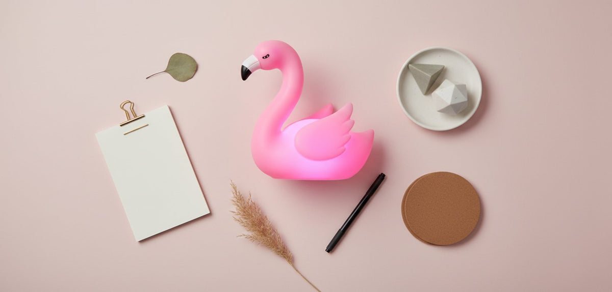 Lampada punto luce flamingo rosa su sfondo rosa con accessori decorativi