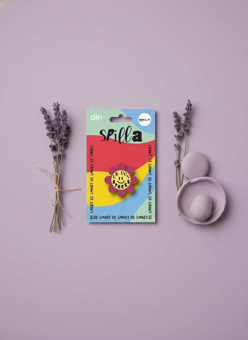 Spilla stress a forma di fiore smiley giallo con petali colorati, confezionata in scatola arcobaleno, circondata da lavanda