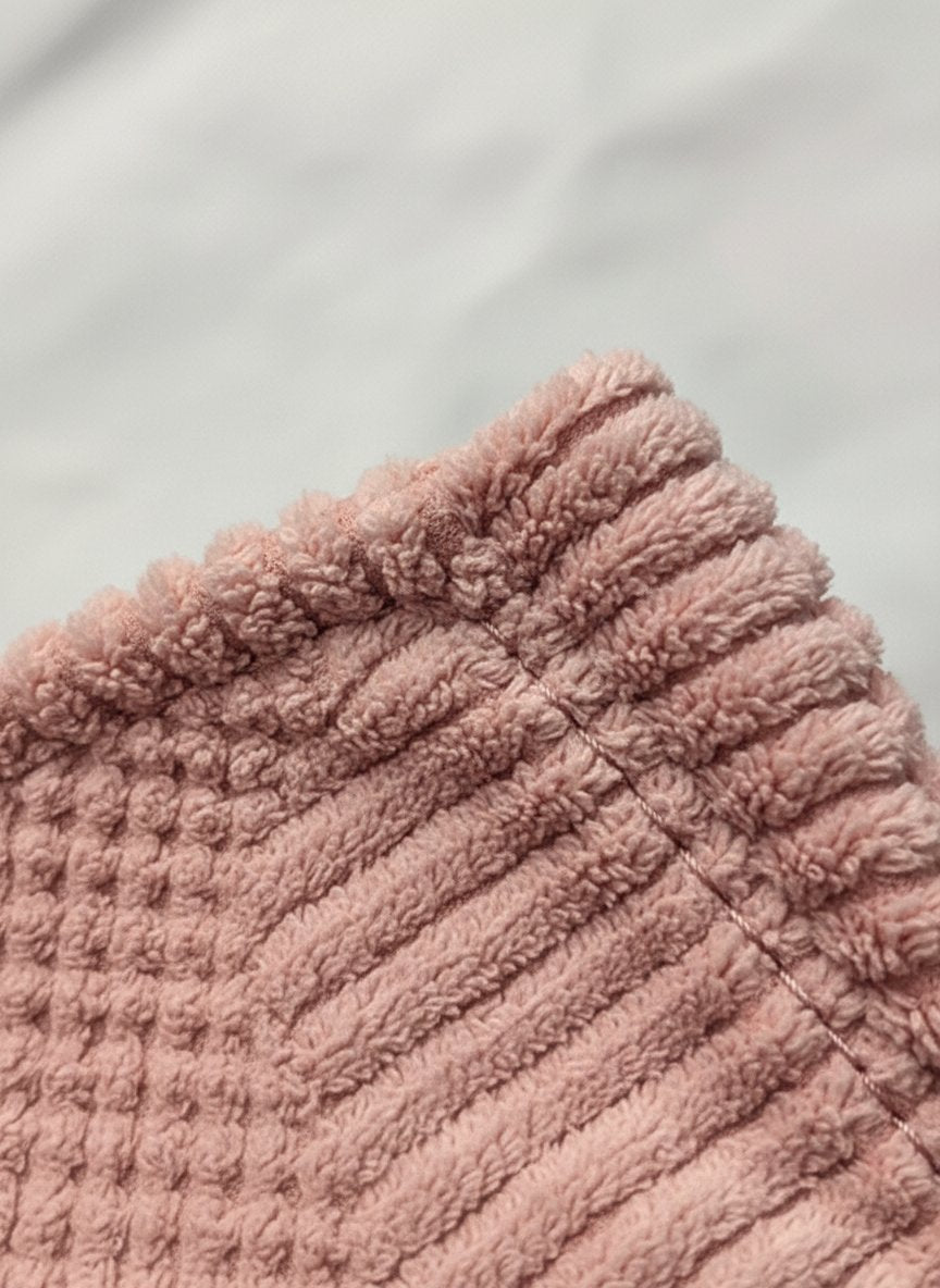Quattro cuffie asciugacapelli in tessuto a nido d'ape nei colori rosa cipria, rosa intenso, bordeaux e beige con etichetta Ta