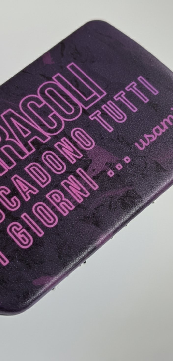 Spazzola per capelli nera con scritte in neon fucsia e manico decorato con fantasia pettini su sfondo rosa