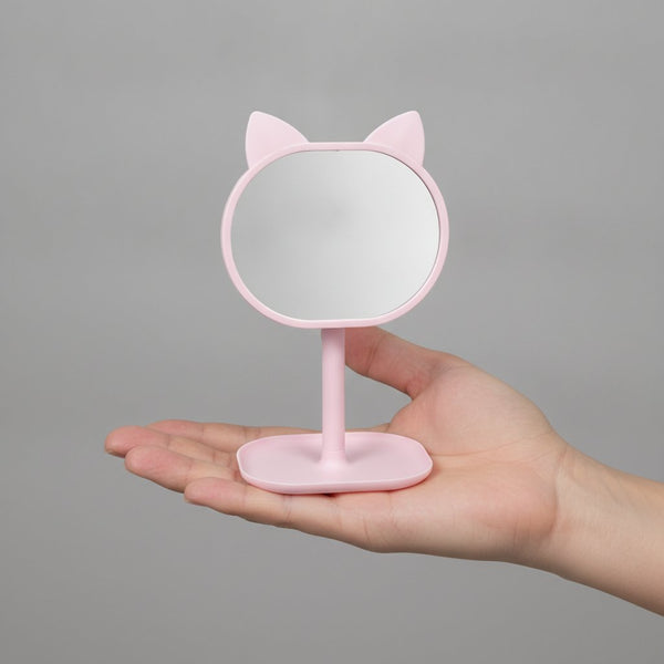 Quattro specchi da trucco con cornice a forma di gatto in colori pastello: rosa, verde menta, pesca e azzurro con base di app