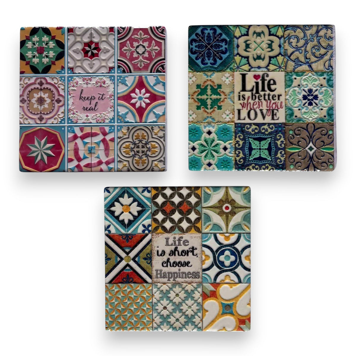 Tre sottobicchieri in maiolica con piastrelle decorative colorate e scritte motivazionali: "keeps it real", "Life is better 