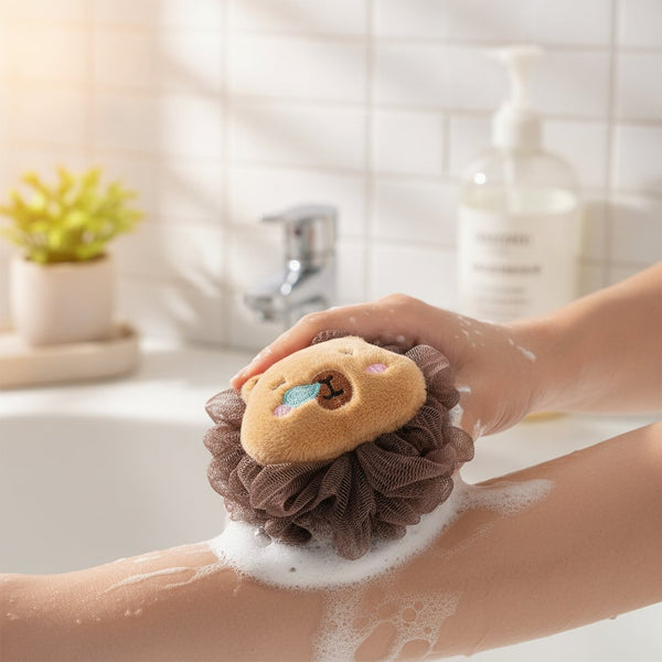 Quattro spugne da bagno a forma di capibara con testa in peluche beige e corona in tulle nei colori marrone, verde acqua, bia
