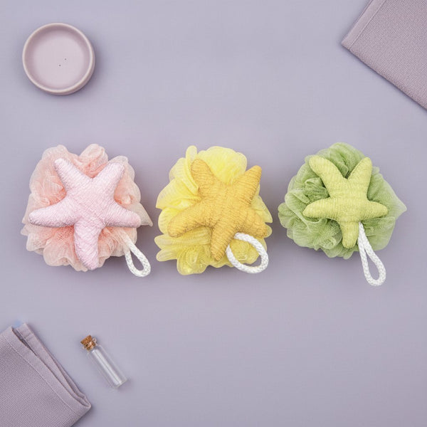 Tre spugne da bagno a forma di stella marina nei colori rosa, giallo e verde con cordino bianco