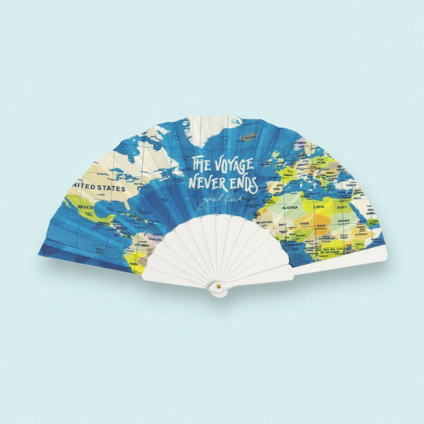 Ventaglio aperto con stampa mappa geografica mondiale in blu, giallo e beige, scritto il voyage never ends