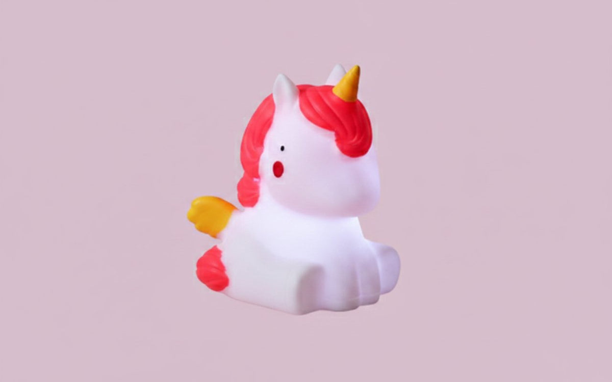 Lampada notturna unicorno bianco con criniera e ali rosa, corno dorato su sfondo rosa