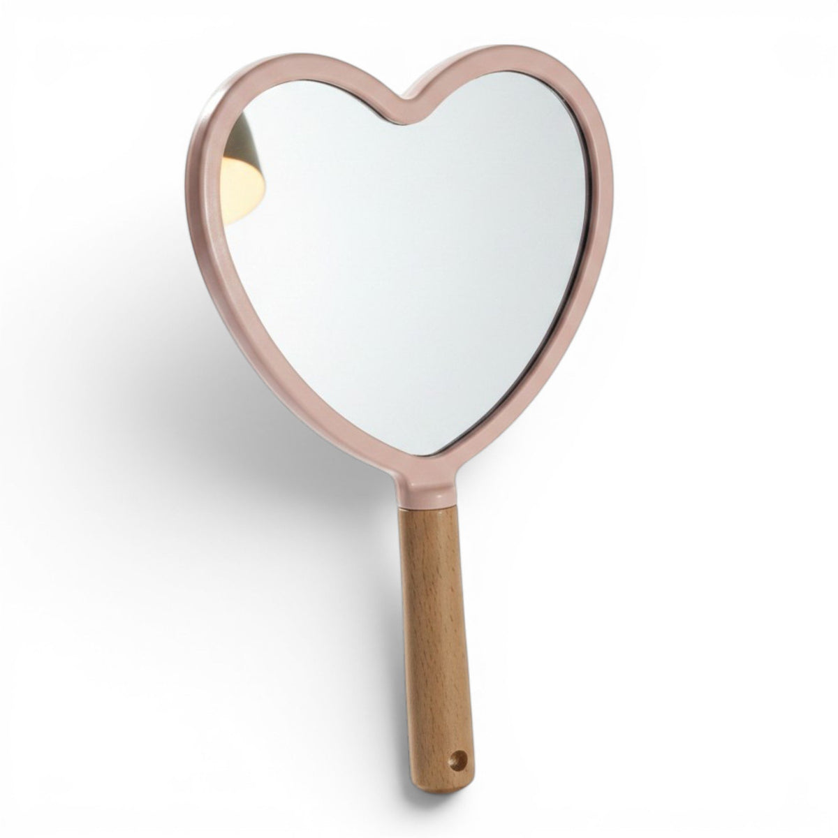 Specchio a forma di cuore con cornice rosa pastello e manico in legno naturale, su sfondo viola