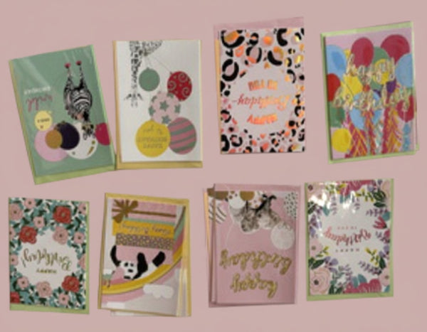 Collezione 8 biglietti auguri colorati con palloncini, fiori, pattern geometrici e scritte augurali su sfondo rosa