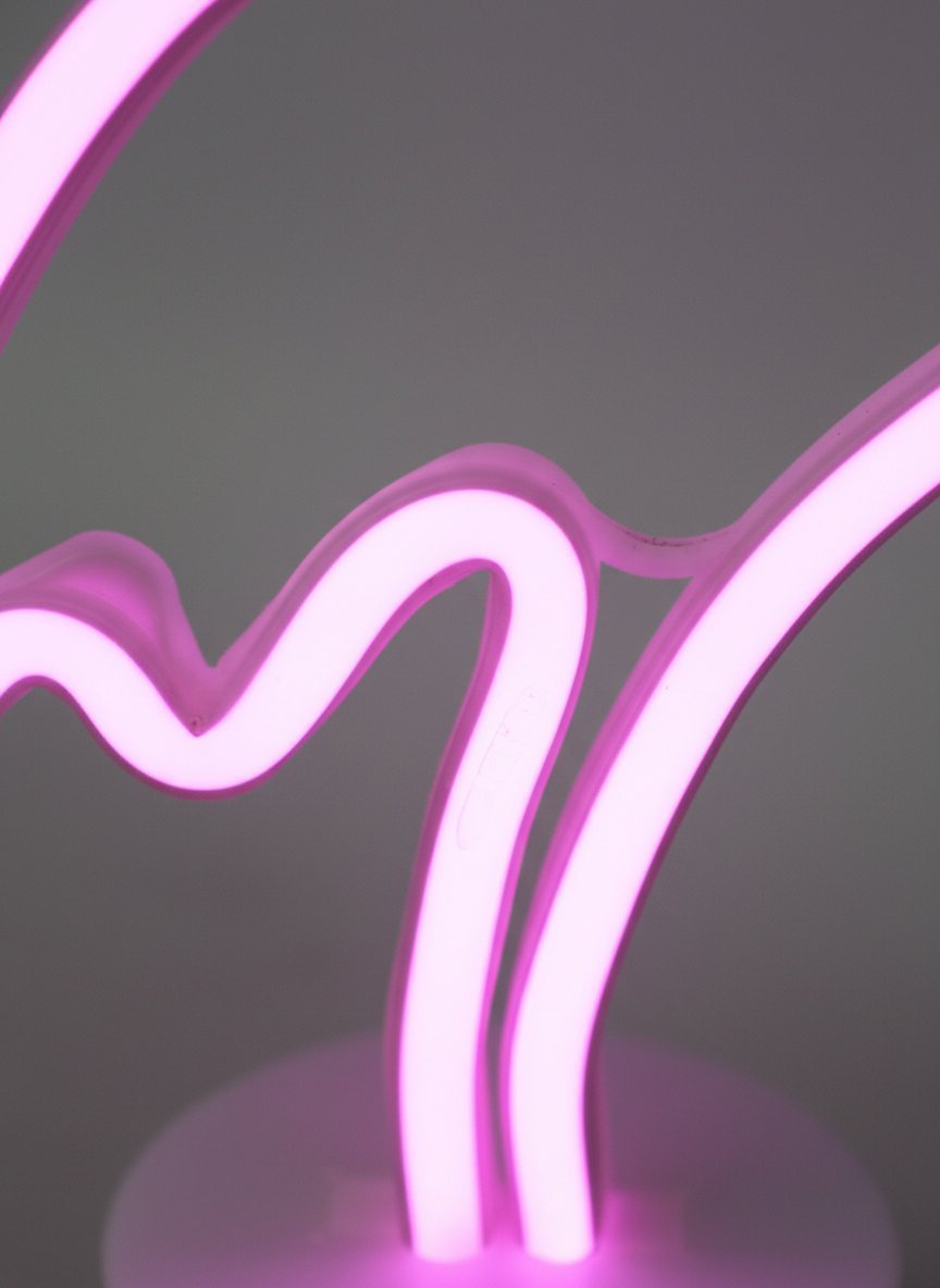 Lampada neon flamingo rosa acceso su sfondo grigio, design curvo elegante con tubo luminoso
