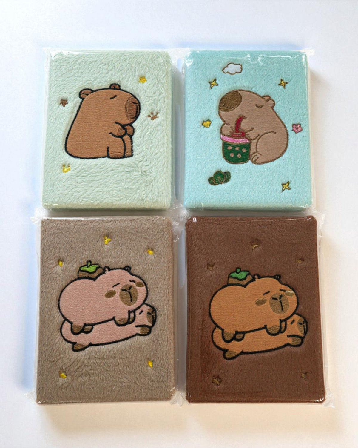 Set 4 notebook capybara colorati con fantasie dolci, copertine in feltro verde, azzurro, beige e marrone