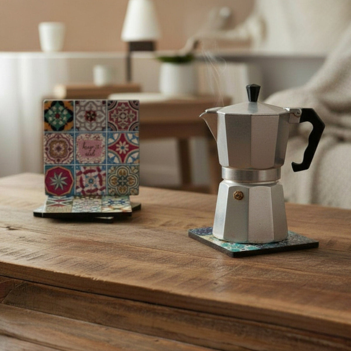 Sottomoka maiolica colorato con piastrelle decorate su tavolo legno accanto a caffettiera moka grigia
